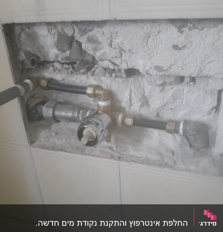 צנרת מים חשופה בקיר עם חיבורים